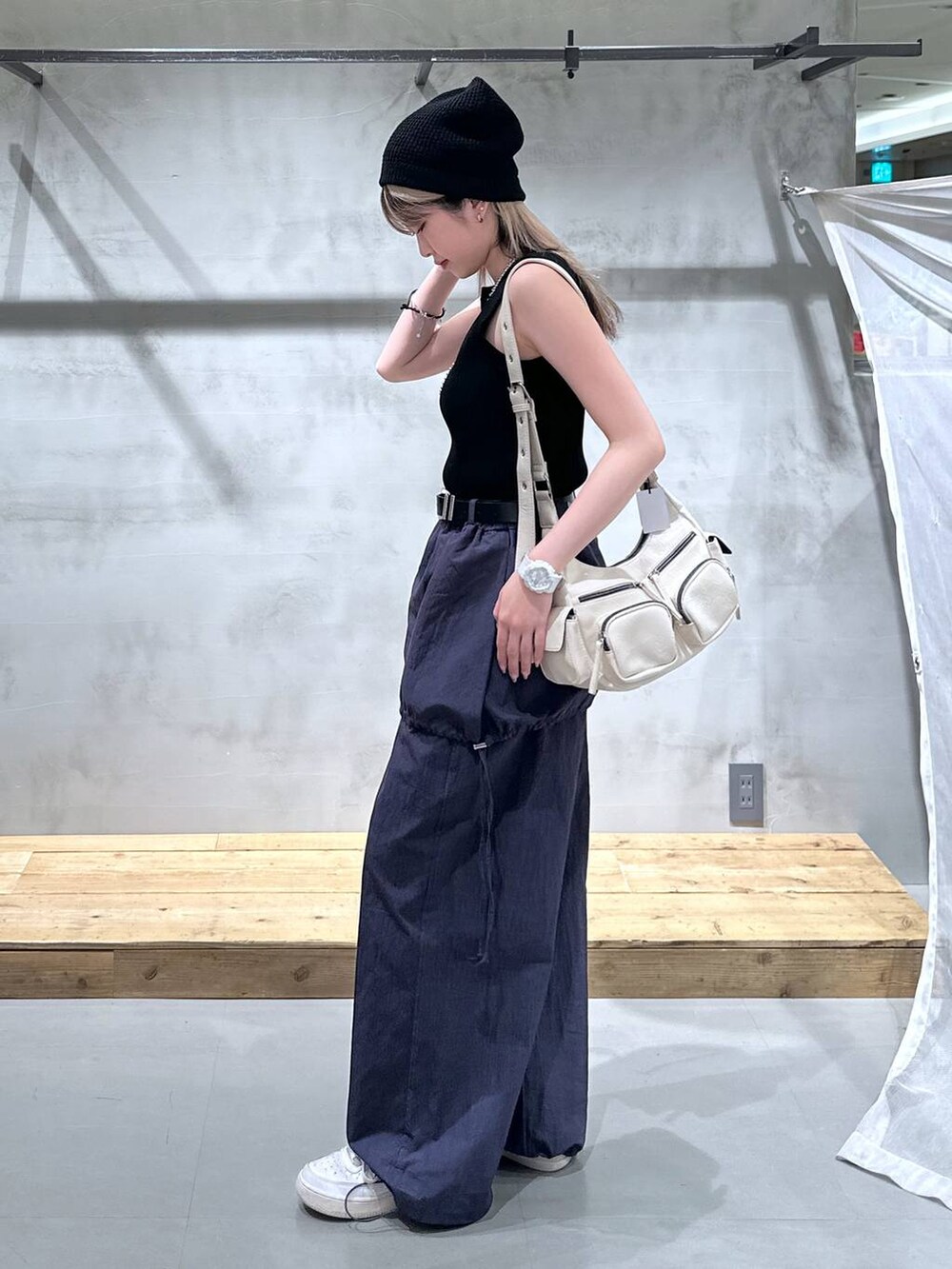 ブラック系のタンクトップ、ホワイト系のショルダーバッグ、ブルー系のサロペット/オーバーオールを着用したレディースの春コーディネートの3枚目の写真