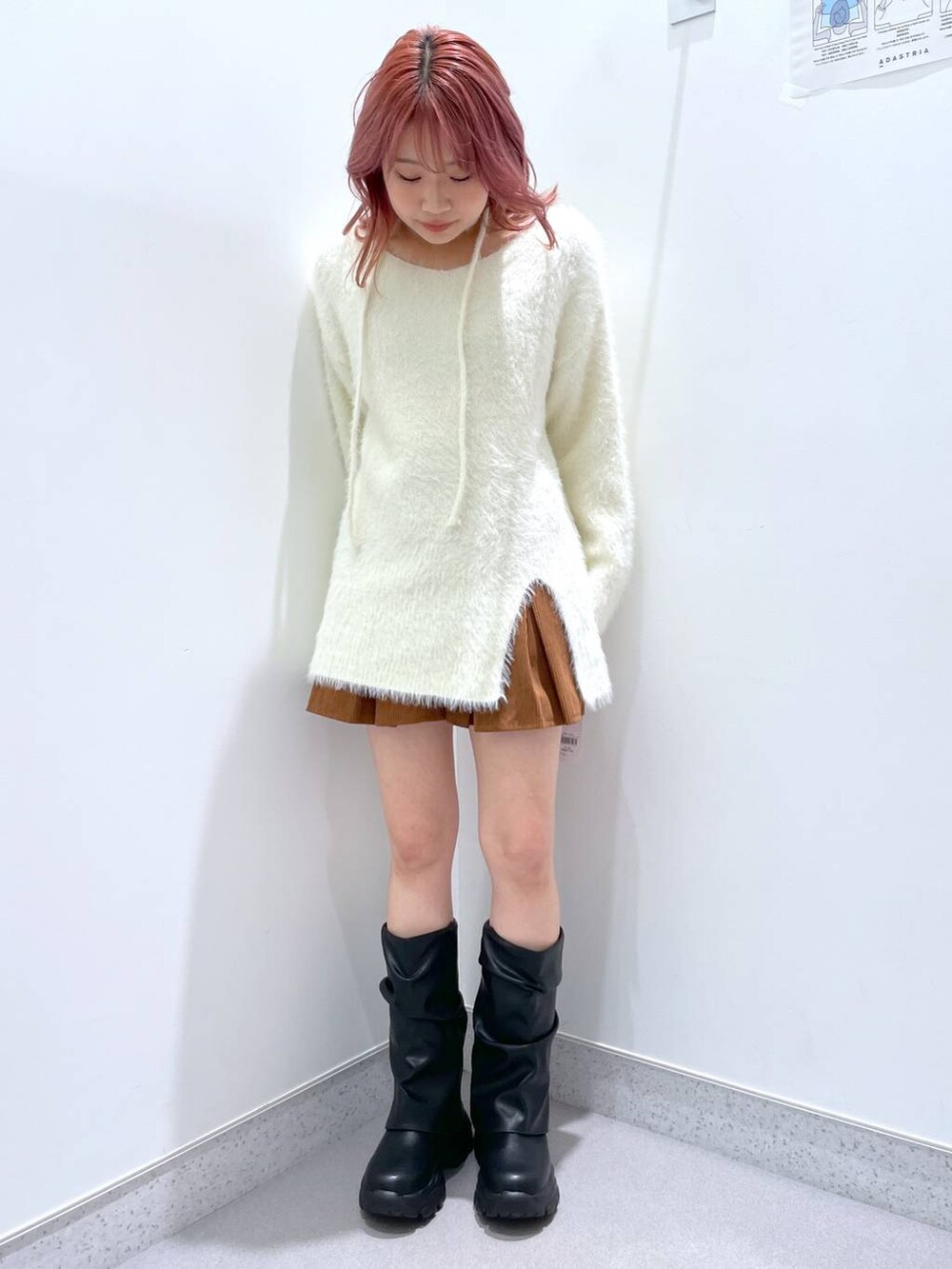 ブラック系のブーツ、イエロー系のスカートを着用したレディースの冬コーディネートの2枚目の写真