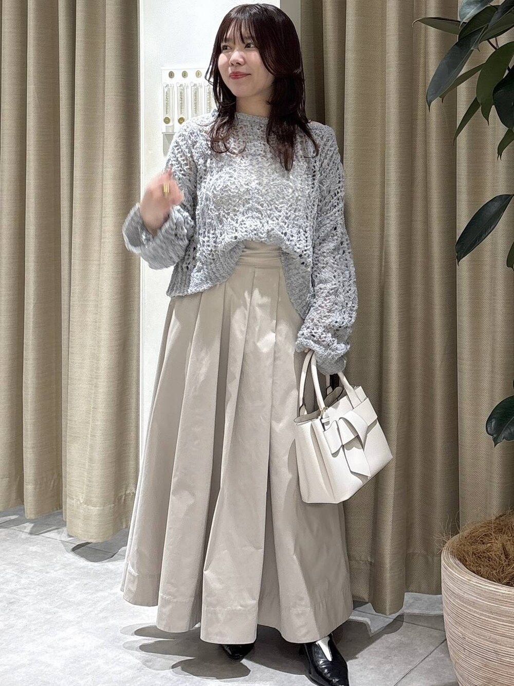 ホワイト系のショルダーバッグ、ブラック系のサンダル、ベージュ系のスカートを着用したレディースの冬コーディネートの2枚目の写真