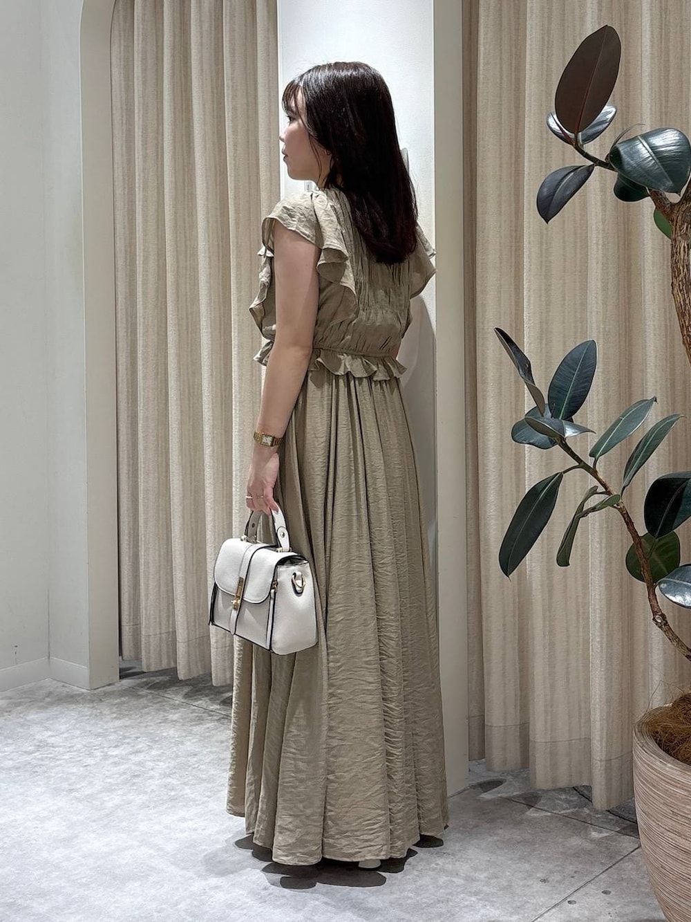 ベージュ系のワンピース、ホワイト系のショルダーバッグ、ゴールド系のネックレスを着用したレディースの夏コーディネートの2枚目の写真
