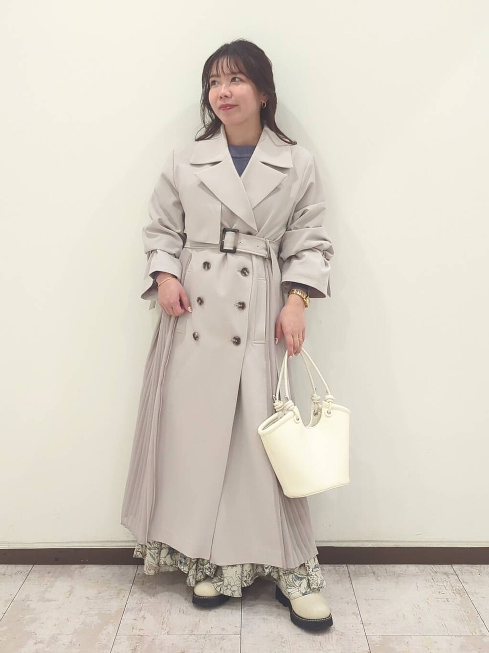 グレー系のニット/セーター、ホワイト系のハンドバッグ、ホワイト系のブーツを着用したレディースの春コーディネートの5枚目の写真