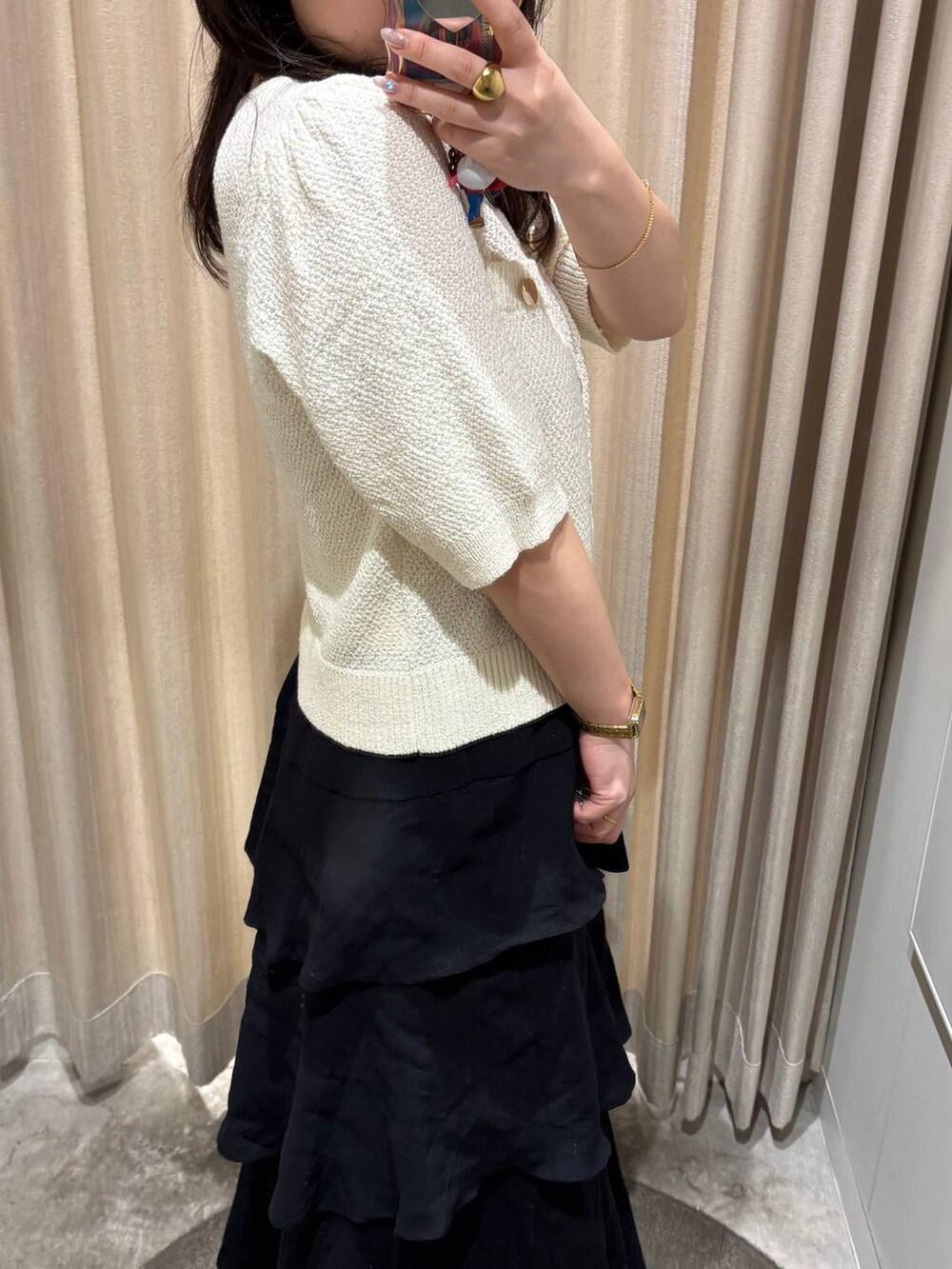 ブラック系のスカート、ホワイト系のカーディガン/ボレロを着用したレディースの夏コーディネートの3枚目の写真