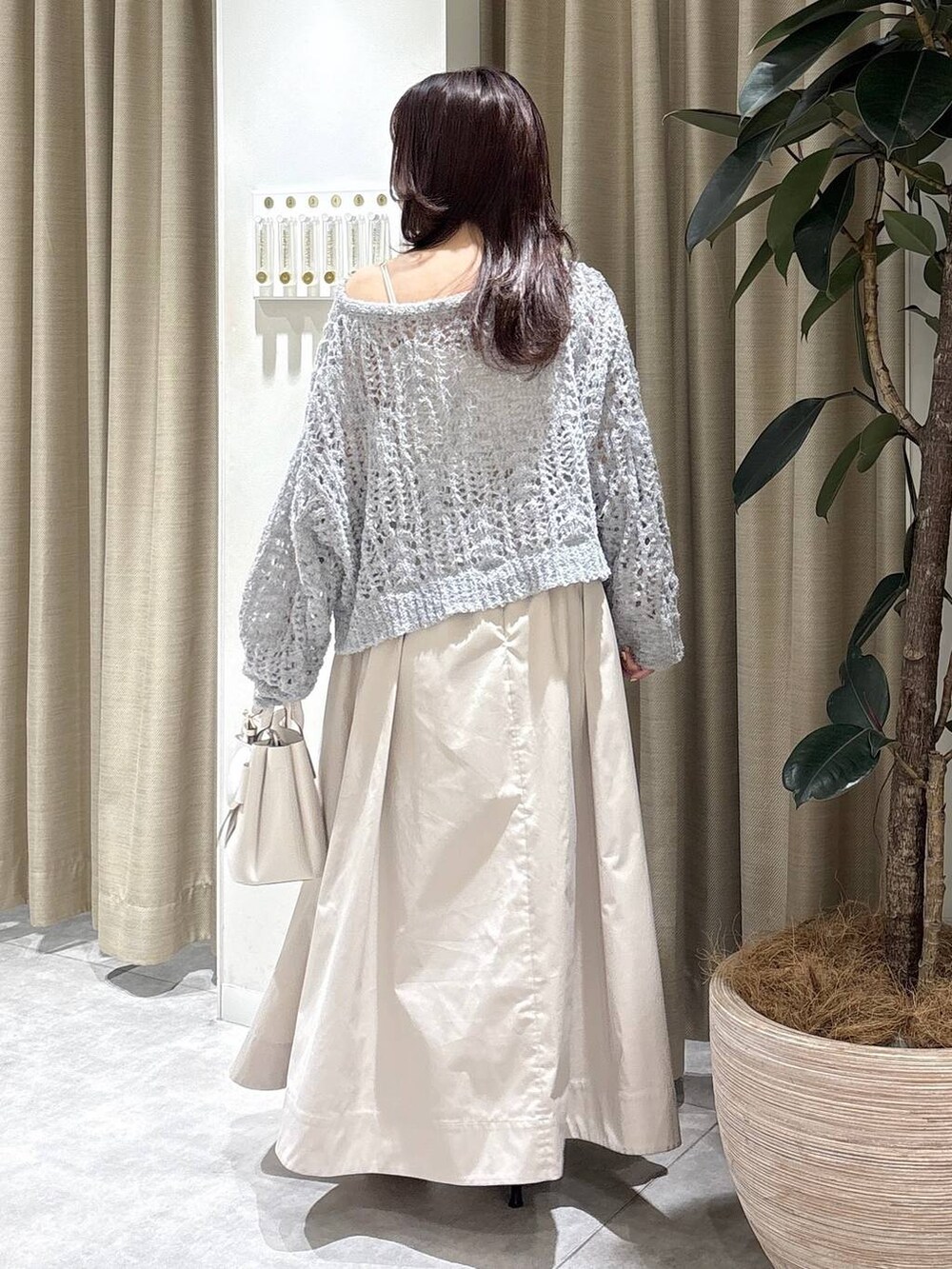 ホワイト系のショルダーバッグ、ブラック系のサンダル、ベージュ系のスカートを着用したレディースの冬コーディネートの4枚目の写真