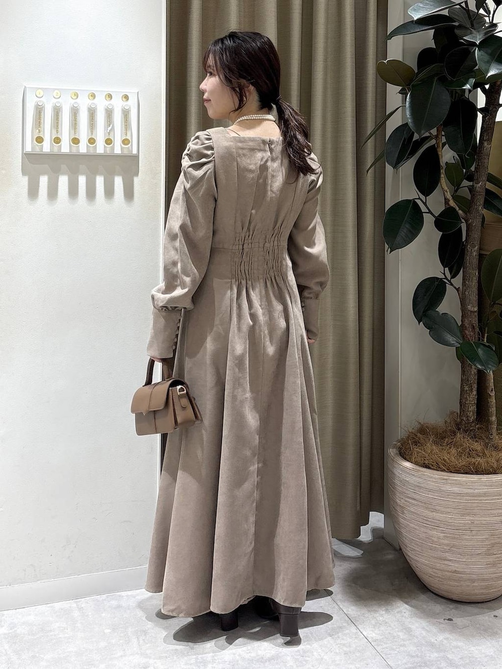 ブラウン系のブーツ、ブラウン系のショルダーバッグ、ベージュ系のワンピースを着用したレディースの冬コーディネートの6枚目の写真