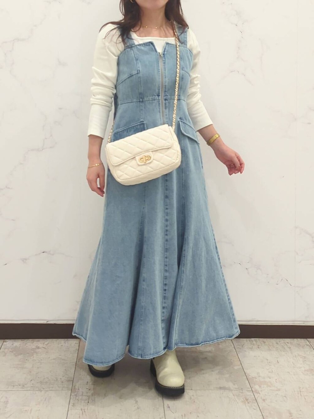 ホワイト系のTシャツ/カットソー、ホワイト系のショルダーバッグ、ホワイト系のブーツを着用したレディースの冬コーディネートの5枚目の写真