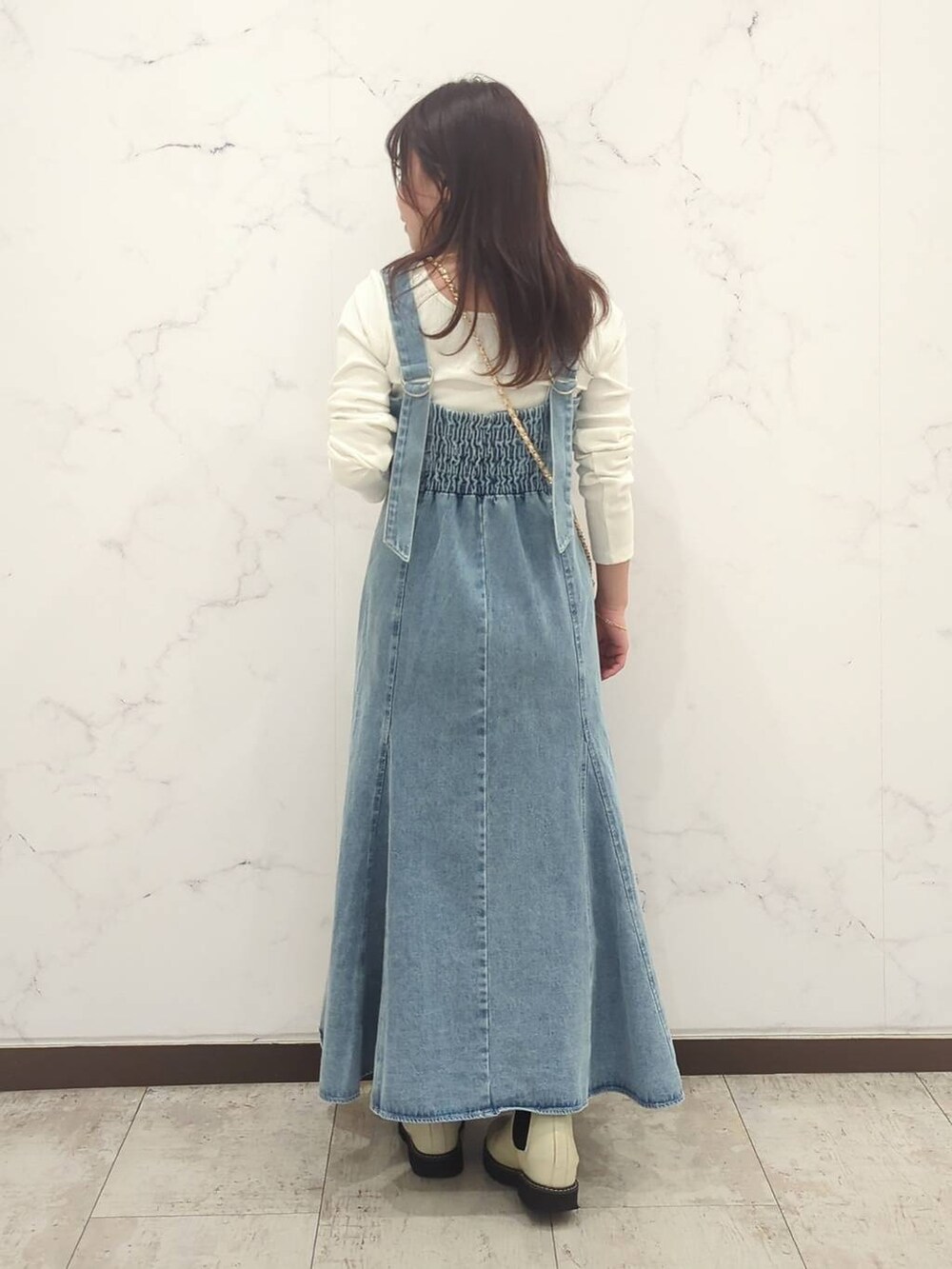 ホワイト系のTシャツ/カットソー、ホワイト系のショルダーバッグ、ホワイト系のブーツを着用したレディースの冬コーディネートの3枚目の写真