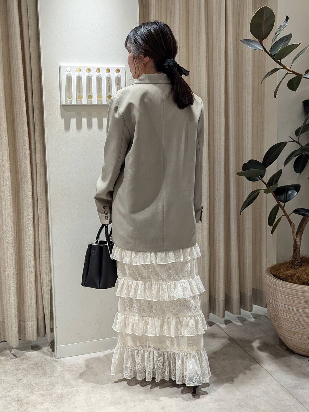 ブラック系のショルダーバッグ、ベージュ系のテーラードジャケット、ホワイト系のTシャツ/カットソーを着用したレディースの冬コーディネートの3枚目の写真