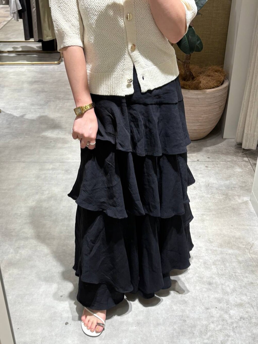 ブラック系のスカート、ホワイト系のカーディガン/ボレロを着用したレディースの夏コーディネートの4枚目の写真