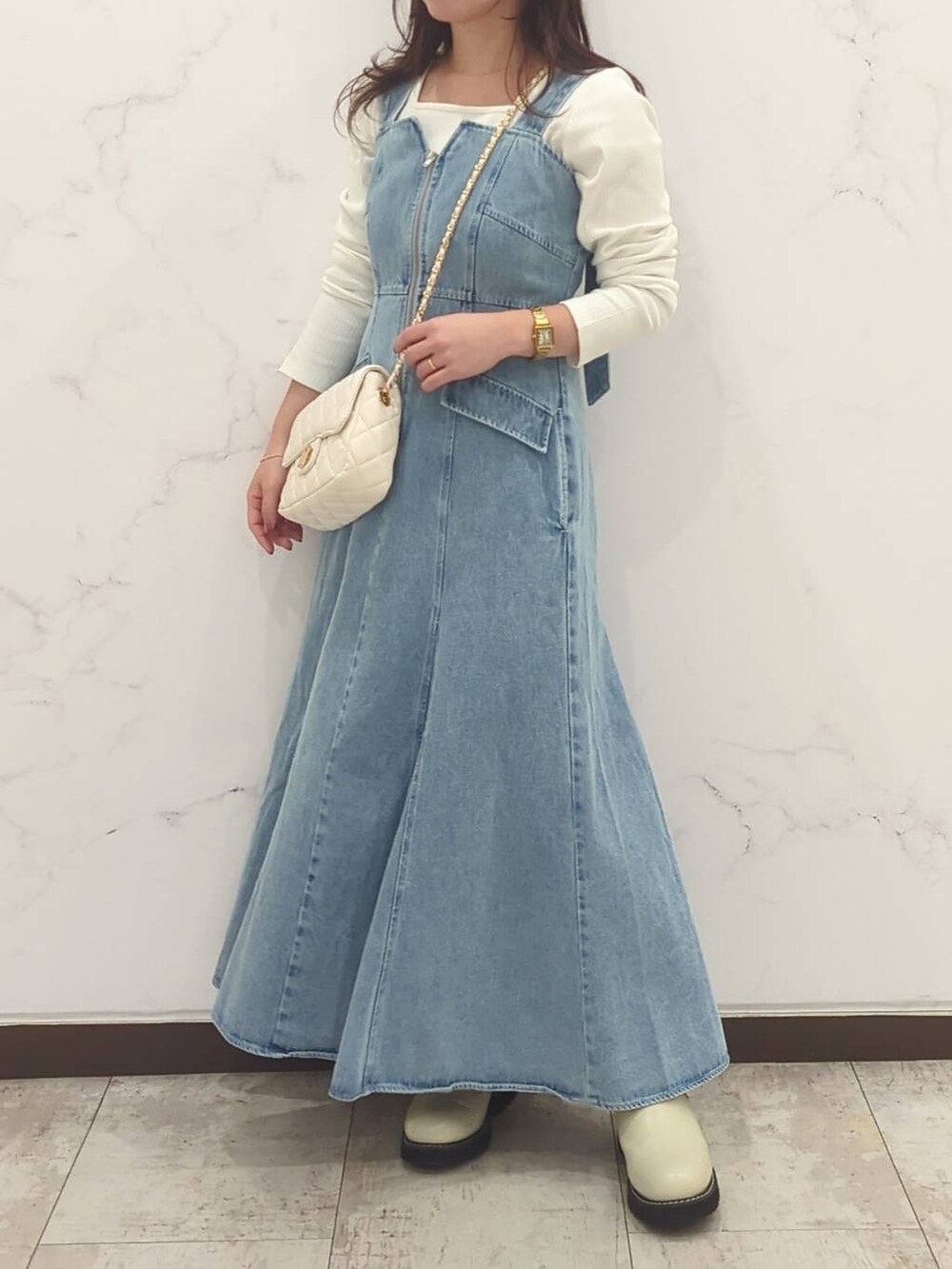 ホワイト系のTシャツ/カットソー、ホワイト系のショルダーバッグ、ホワイト系のブーツを着用したレディースの冬コーディネートの4枚目の写真