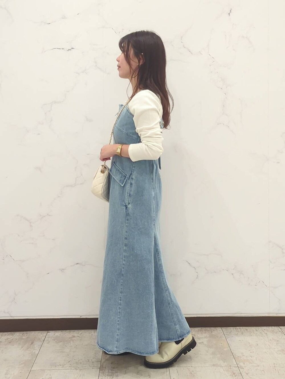 ホワイト系のTシャツ/カットソー、ホワイト系のショルダーバッグ、ホワイト系のブーツを着用したレディースの冬コーディネートの2枚目の写真