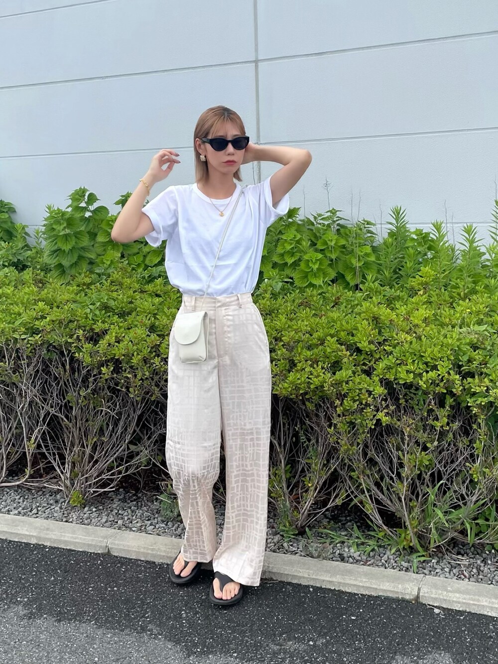 ホワイト系のその他パンツ、ブラック系のサンダル、ホワイト系のショルダーバッグを着用したレディースの夏コーディネートの2枚目の写真
