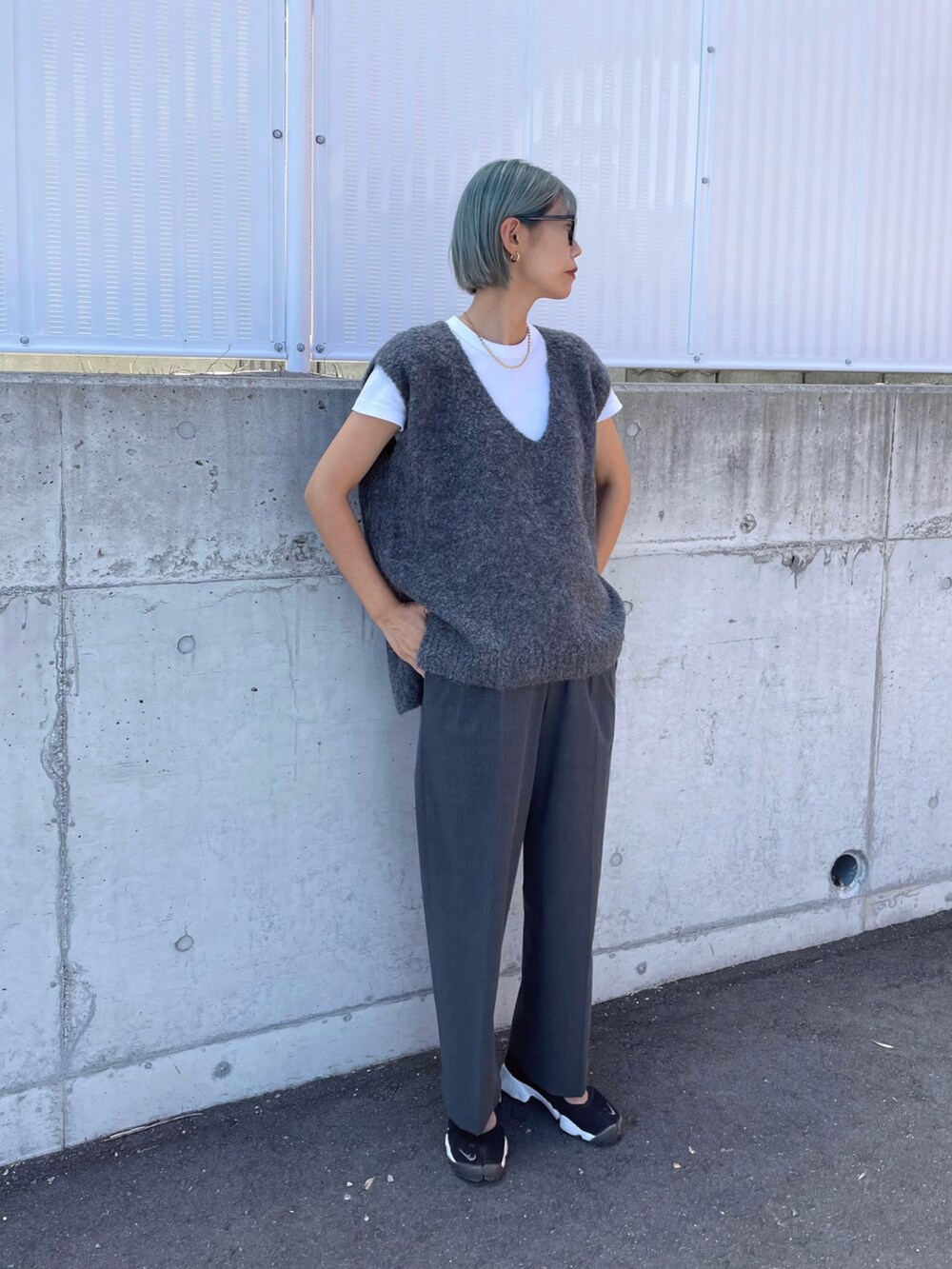 ブラック系のスニーカー、グレー系のベスト、グレー系のパンツを着用したレディースの秋コーディネートの3枚目の写真