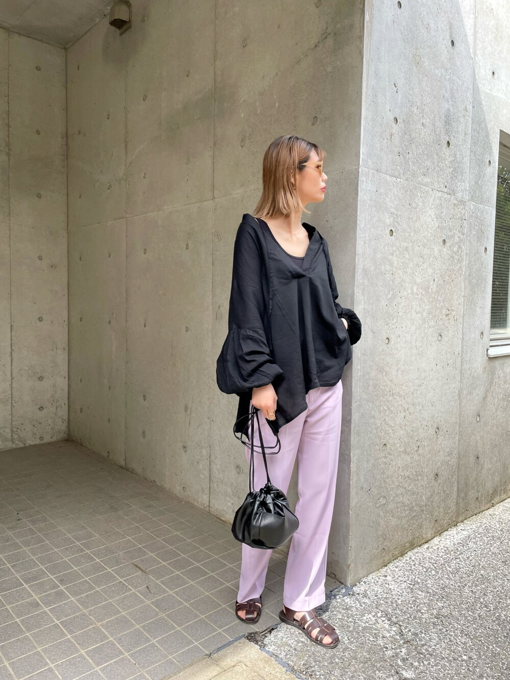 ブラック系のシャツ/ブラウス、ホワイト系のショルダーバッグ、パープル系のスラックスを着用したレディースの春コーディネートの3枚目の写真