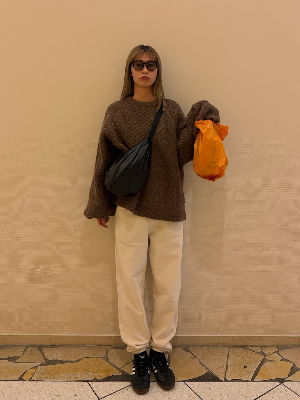 ホワイト系のスウェットパンツ、ブラック系のスニーカー、ブラウン系のニット/セーターを着用したレディースの冬コーディネートの2枚目の写真