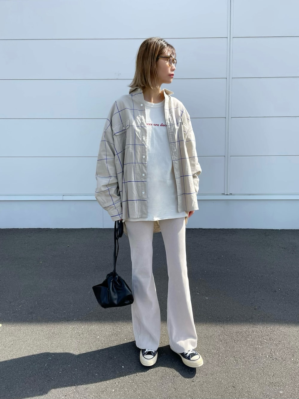 ベージュ系のトップス、ホワイト系のショルダーバッグ、ブラック系のシューズを着用したレディースの春コーディネートの2枚目の写真