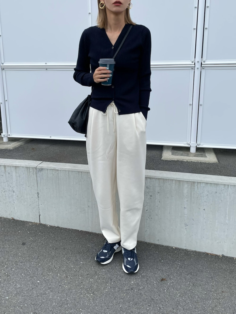 ブルー系のトップス、ホワイト系のパンツ、ブルー系のスニーカーを着用したレディースの秋コーディネートの2枚目の写真