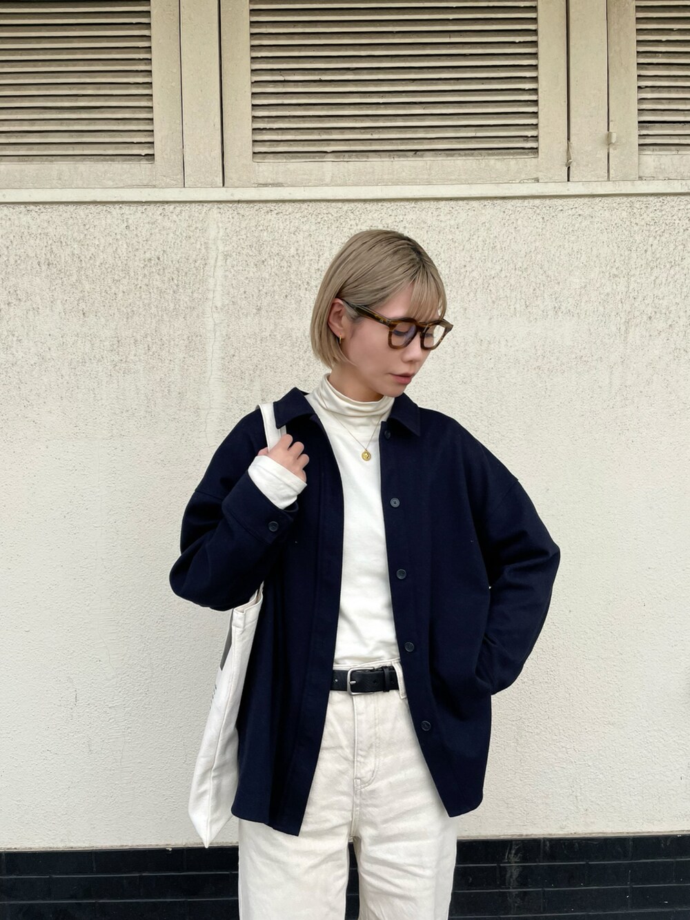 ホワイト系のTシャツ/カットソー、ホワイト系のパンツ、ブルー系のスニーカーを着用したレディースの春コーディネートの3枚目の写真