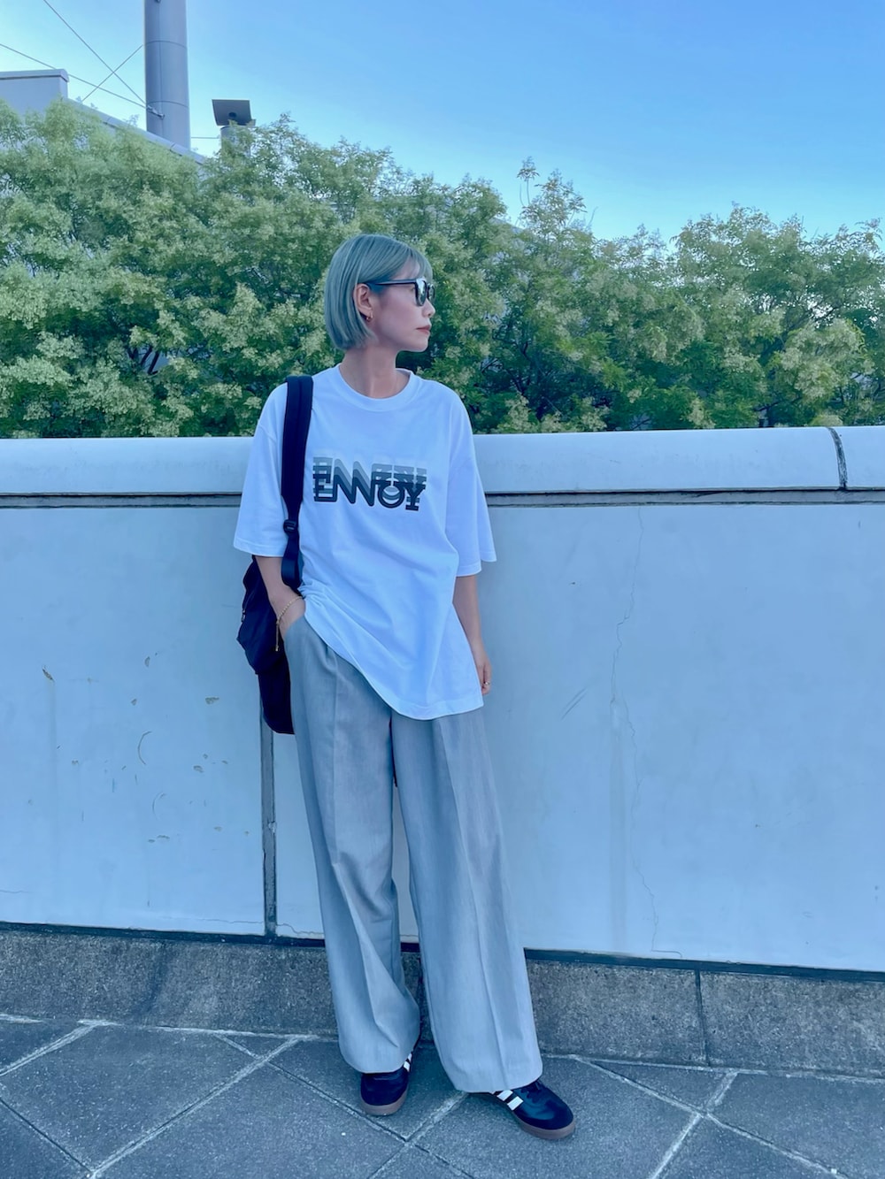 ブラック系のバックパック/リュック、グレー系のスラックス、ホワイト系のトップスを着用したレディースの秋コーディネートの2枚目の写真