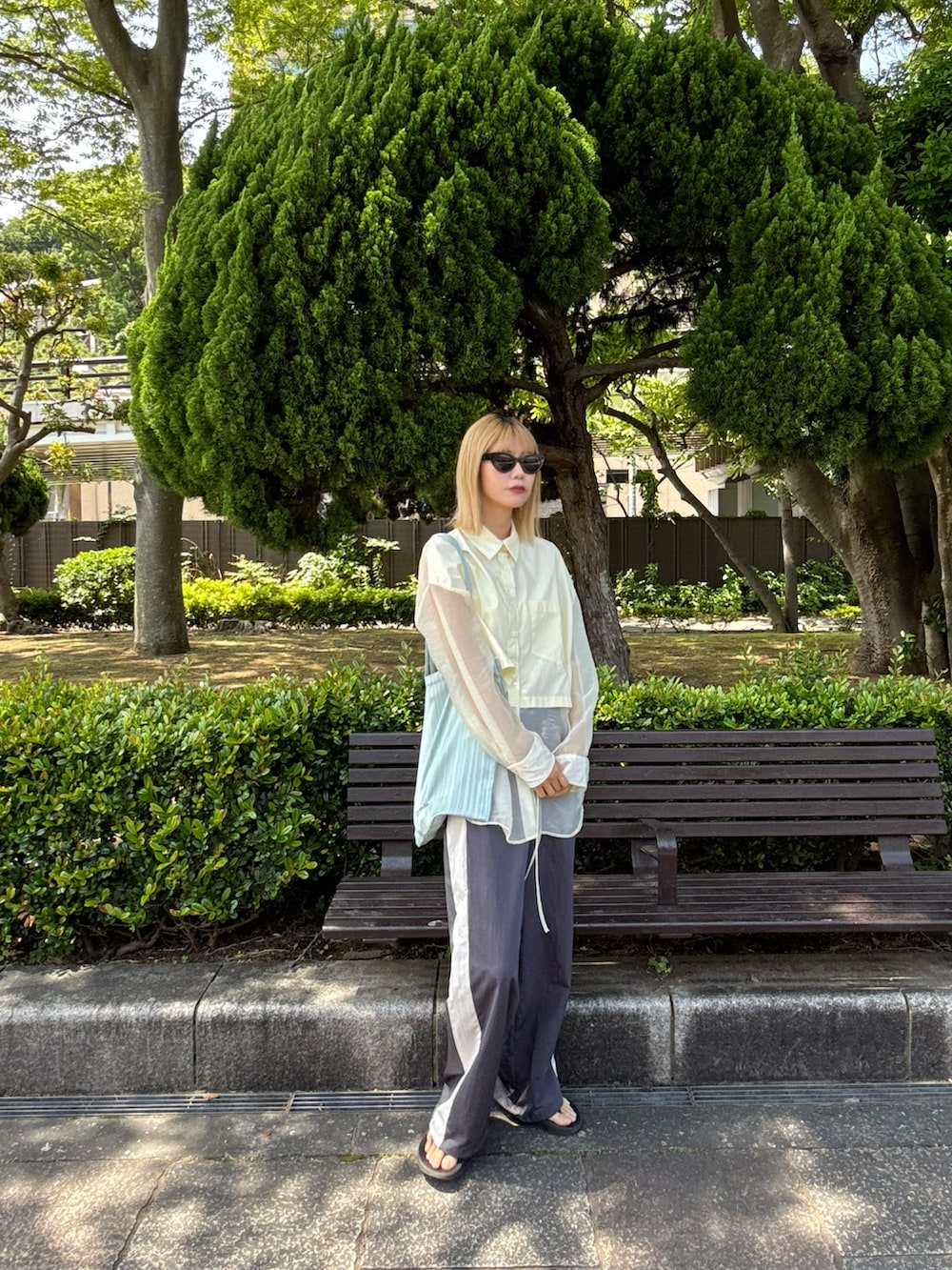 イエロー系のトップス、グレー系のその他パンツ、ブラック系のサンダルを着用したレディースの夏コーディネートの2枚目の写真