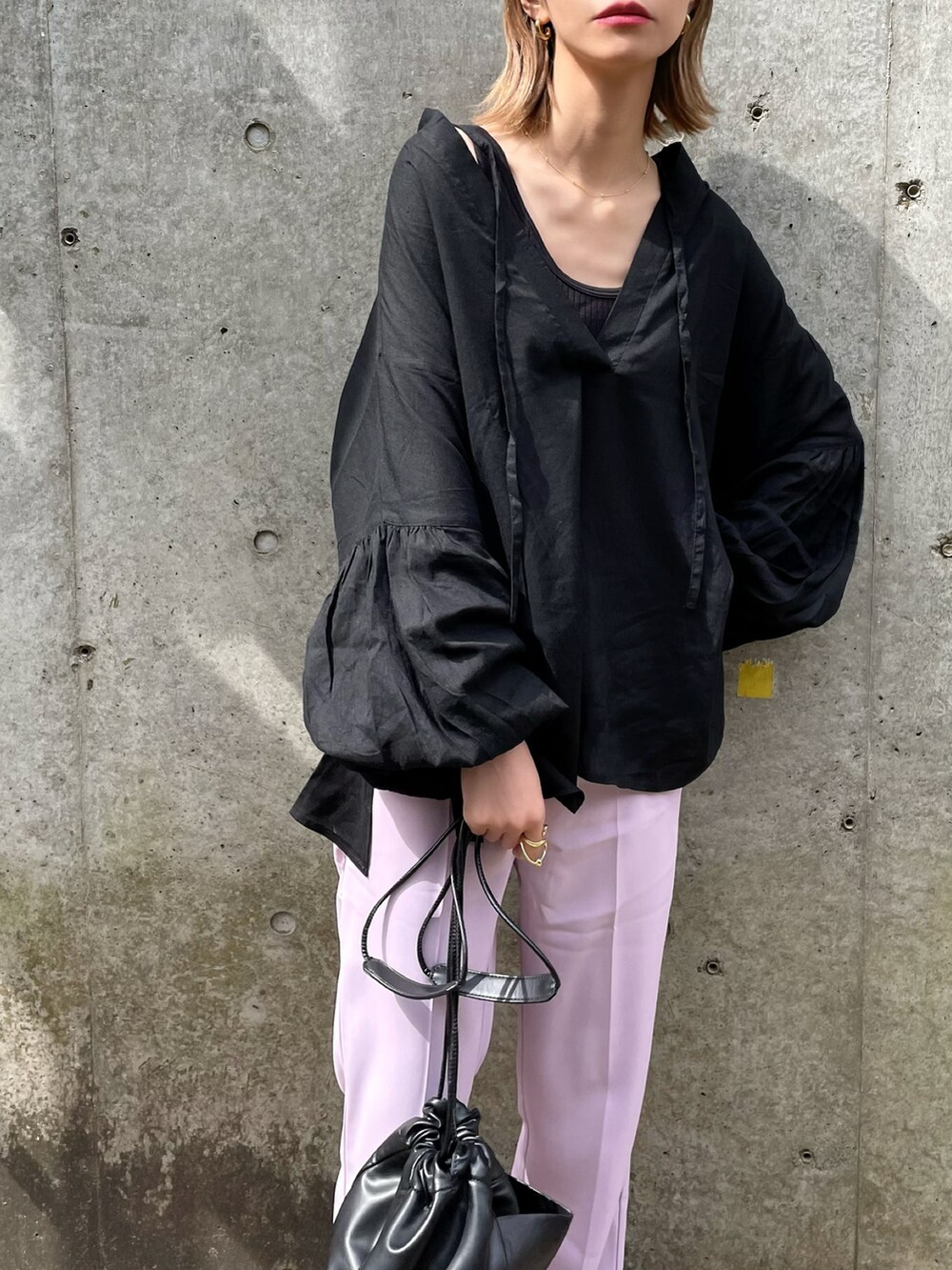 ブラック系のシャツ/ブラウス、ホワイト系のショルダーバッグ、パープル系のスラックスを着用したレディースの春コーディネートの2枚目の写真