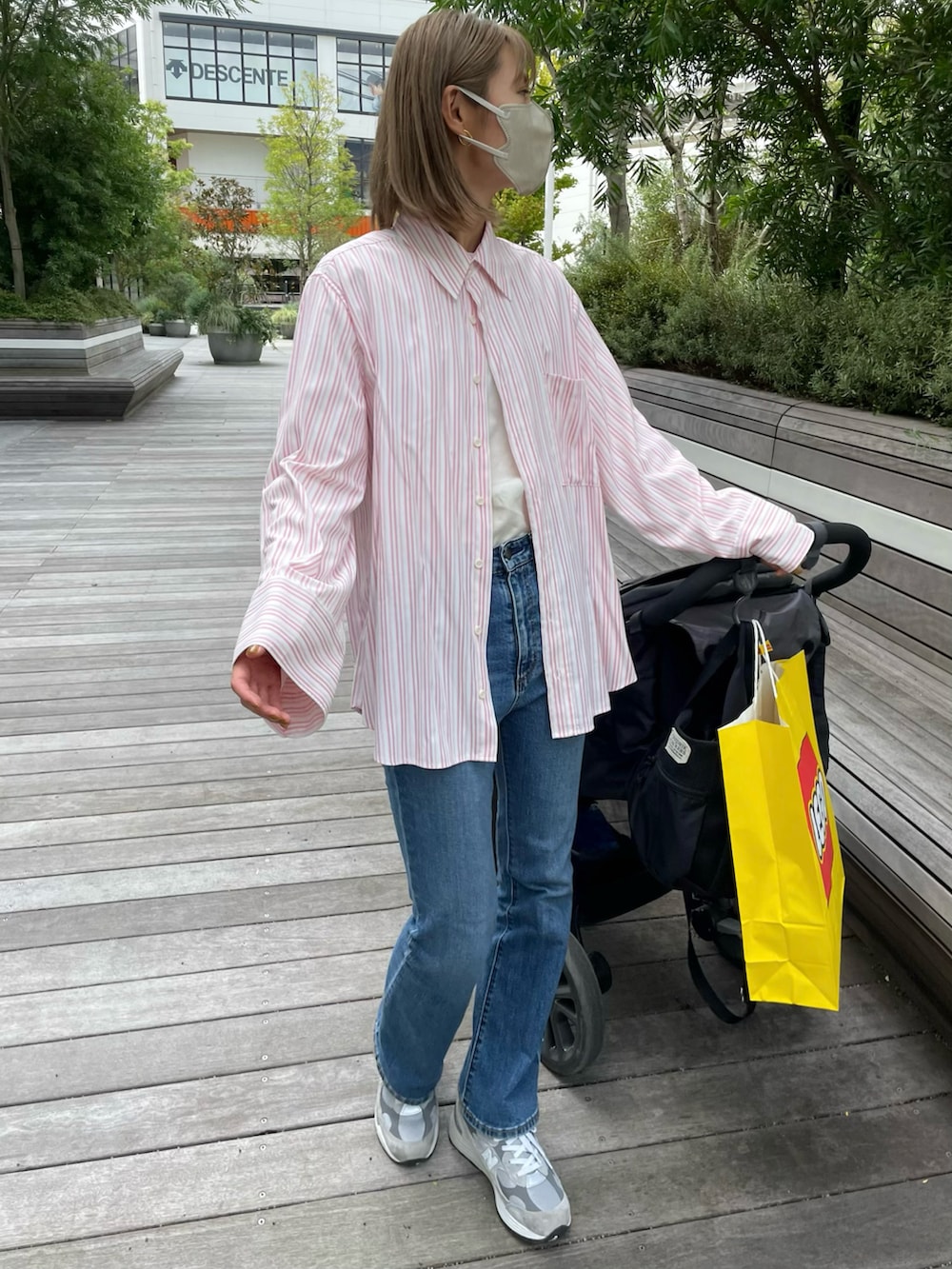 ピンク系のシャツ/ブラウス、ブルー系のパンツ、グレー系のスニーカーを着用したレディースの秋コーディネートの2枚目の写真