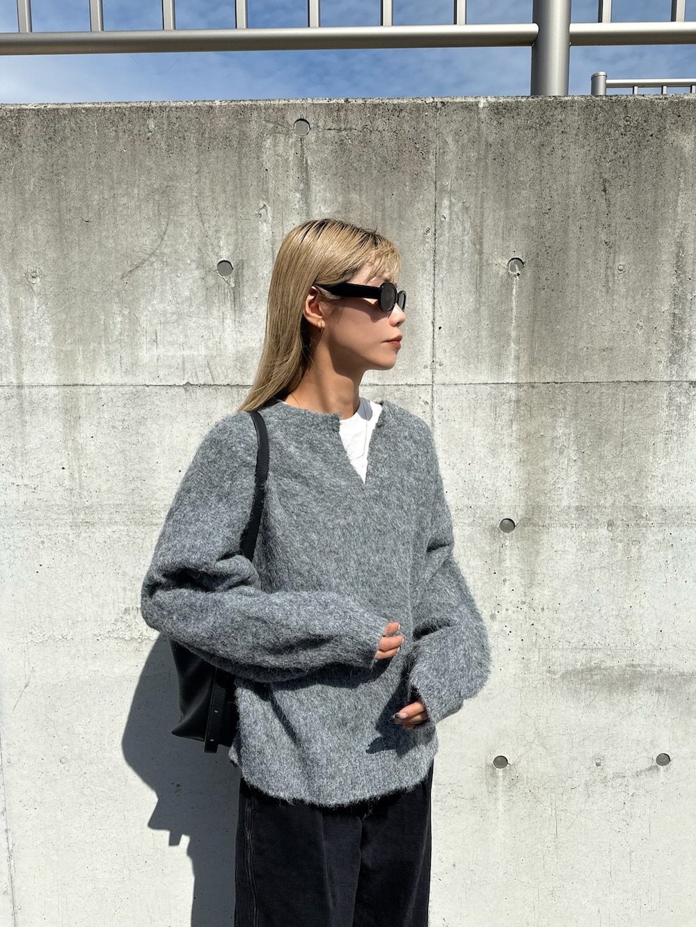 グレー系のニット/セーター、ブラック系のサンダルを着用したレディースの秋コーディネートの2枚目の写真