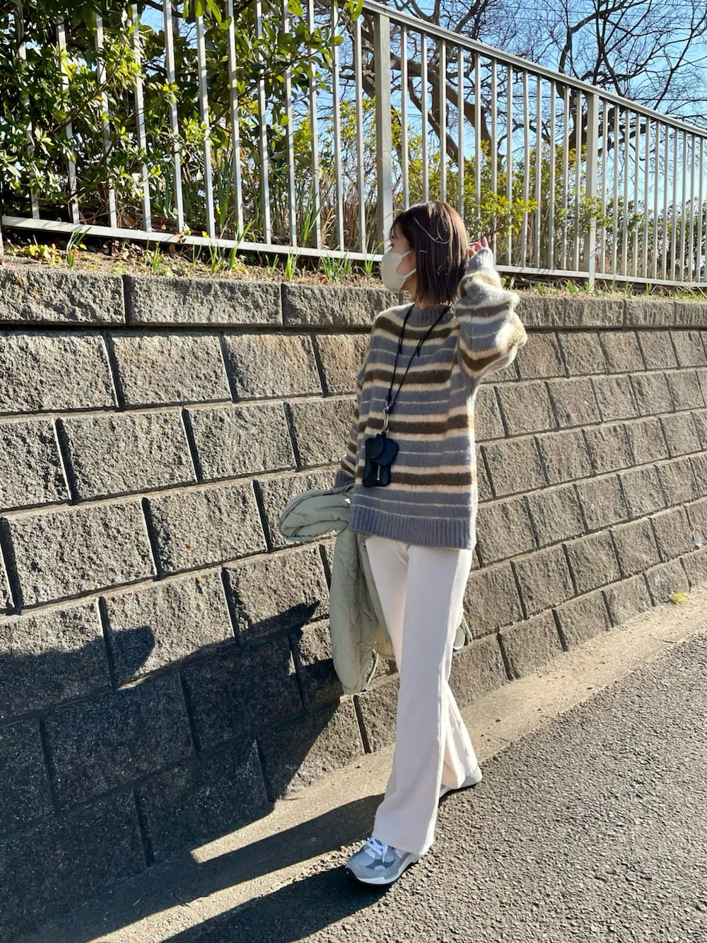 ブラック系のバッグ、グレー系のスニーカー、グレー系のトップスを着用したレディースの冬コーディネートの2枚目の写真