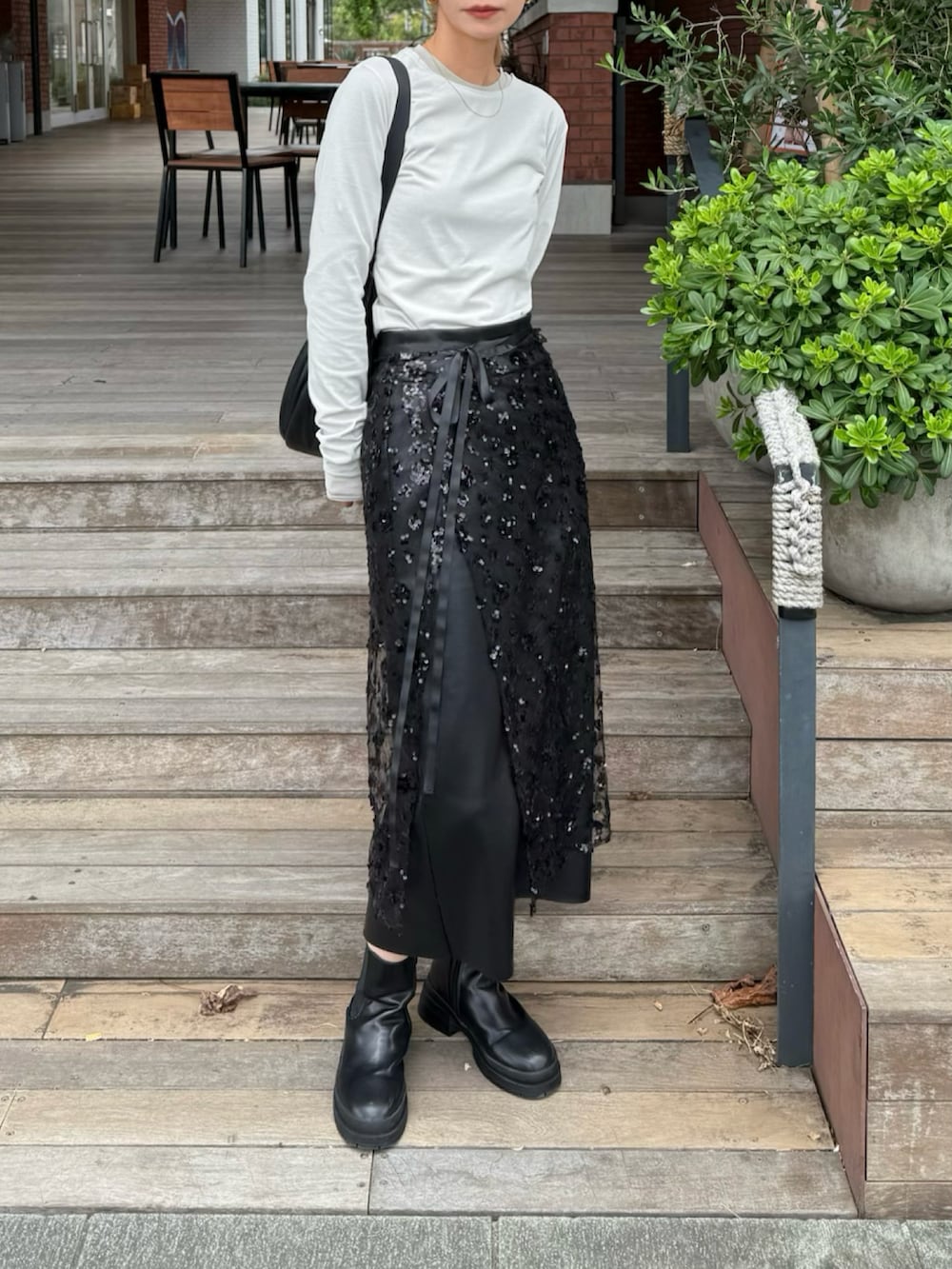 ベージュ系のTシャツ/カットソー、ブラック系のスカートを着用したレディースの秋コーディネートの2枚目の写真