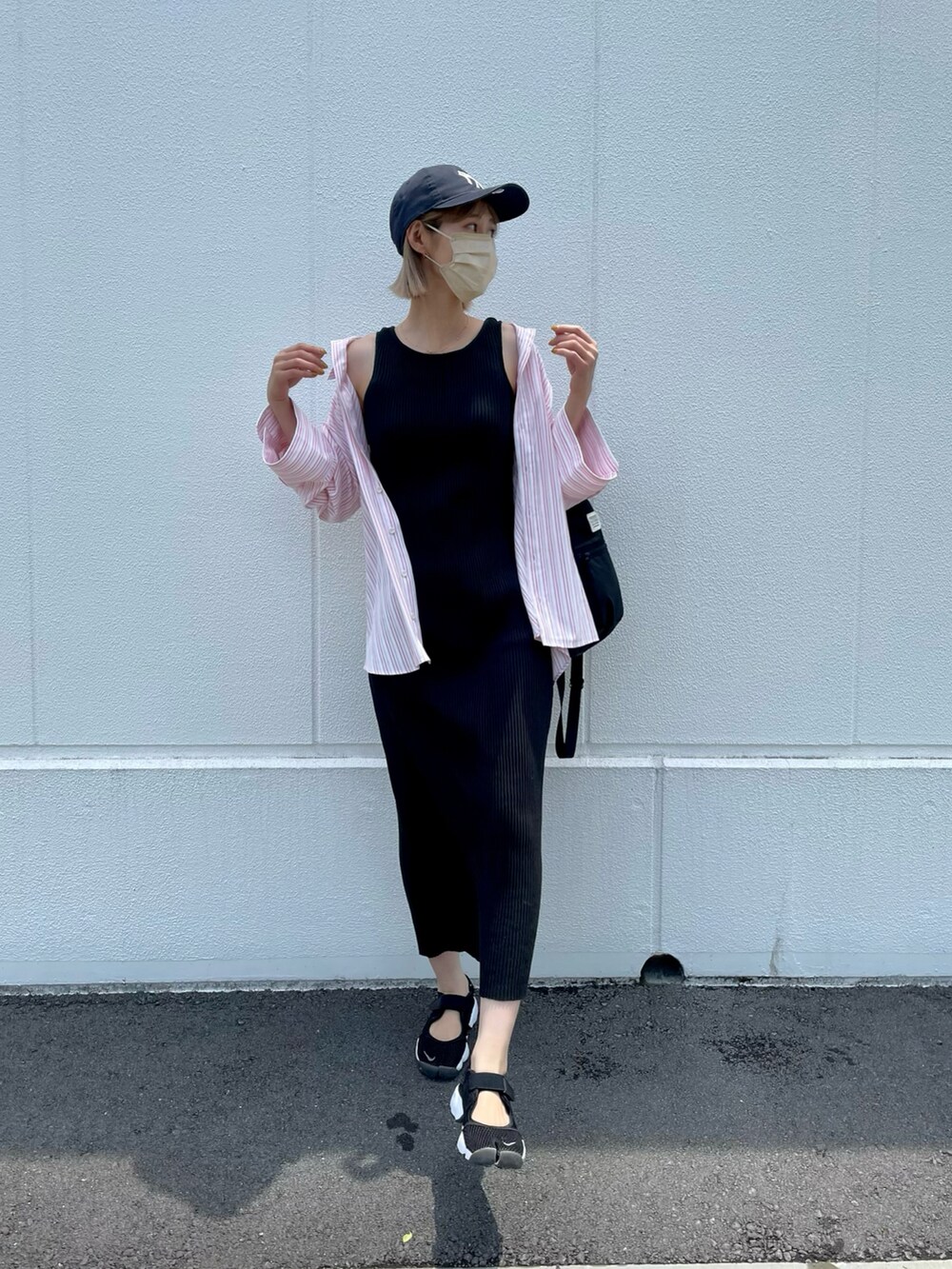 ピンク系のシャツ/ブラウス、ブラック系のワンピース、ブラック系のスニーカーを着用したレディースの春コーディネートの2枚目の写真