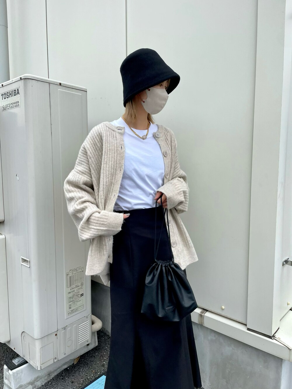 ホワイト系のTシャツ/カットソー、ブラック系のスカート、ブラック系のショルダーバッグを着用したレディースの秋コーディネートの3枚目の写真