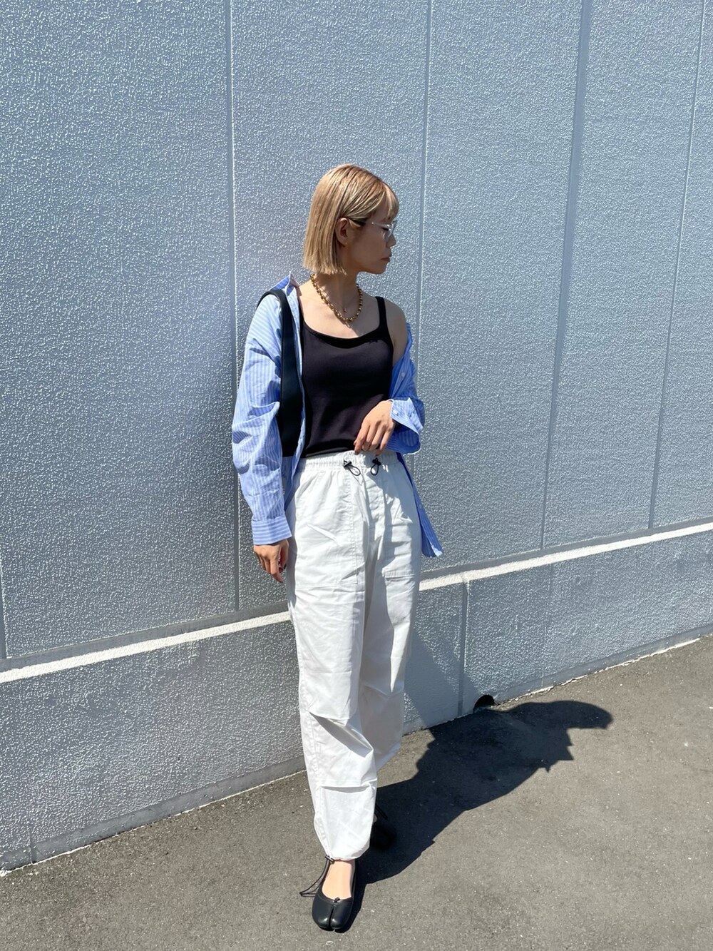 ホワイト系のカーゴパンツ、ブラック系のパンプス、ブラック系のトップスを着用したレディースの春コーディネートの3枚目の写真