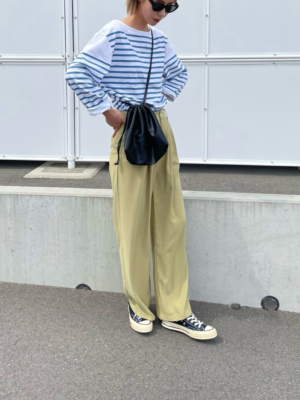 ブルー系のトップス、ブラック系のショルダーバッグ、ブラック系のシューズを着用したレディースの春コーディネートの2枚目の写真