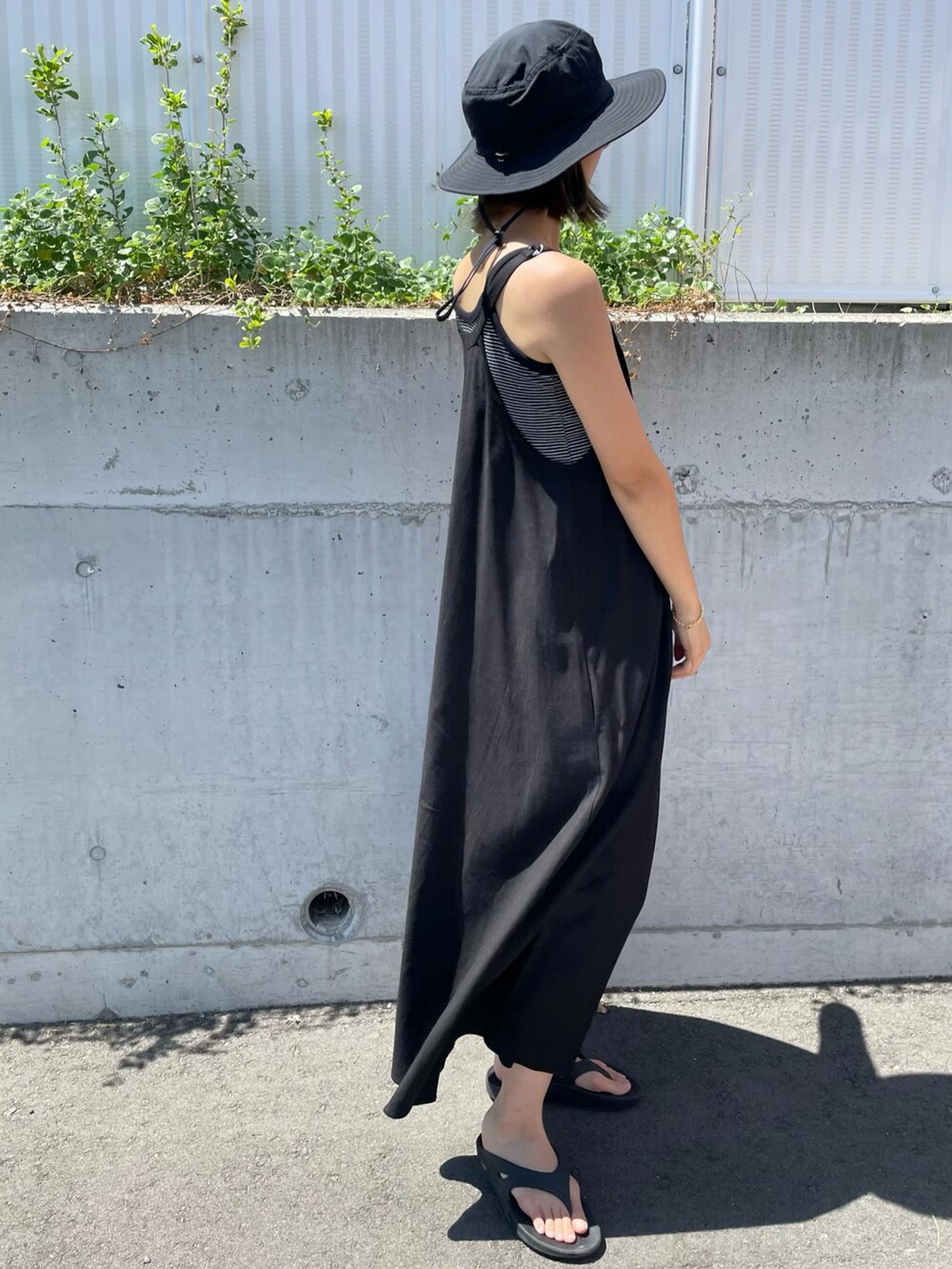 ブラック系のワンピース、ブラック系のサンダル、ブラック系のキャミソールを着用したレディースの夏コーディネートの3枚目の写真