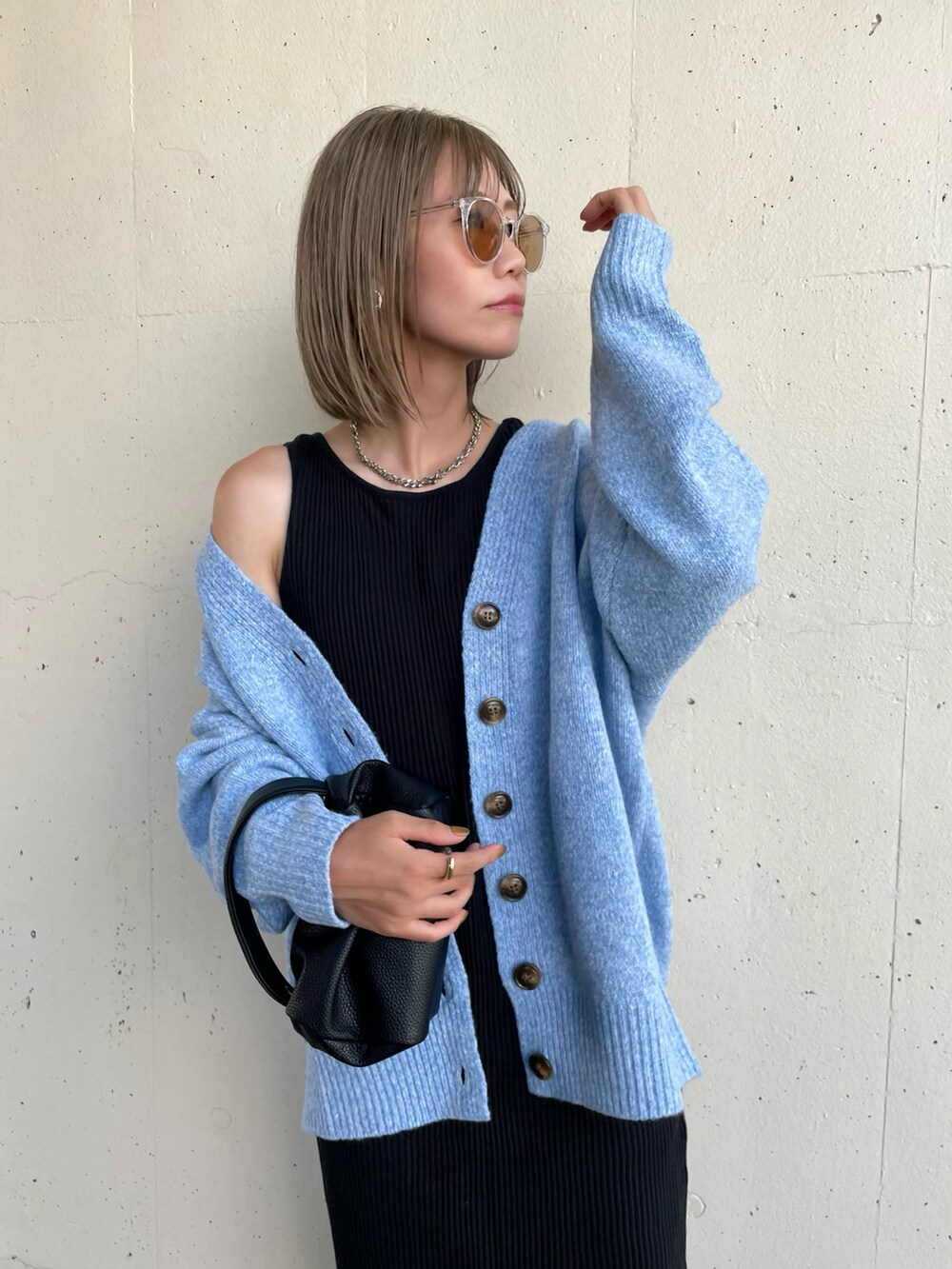 ブラック系のワンピース、ブラック系のブーツ、ブラック系のハンドバッグを着用したレディースの秋コーディネートの2枚目の写真