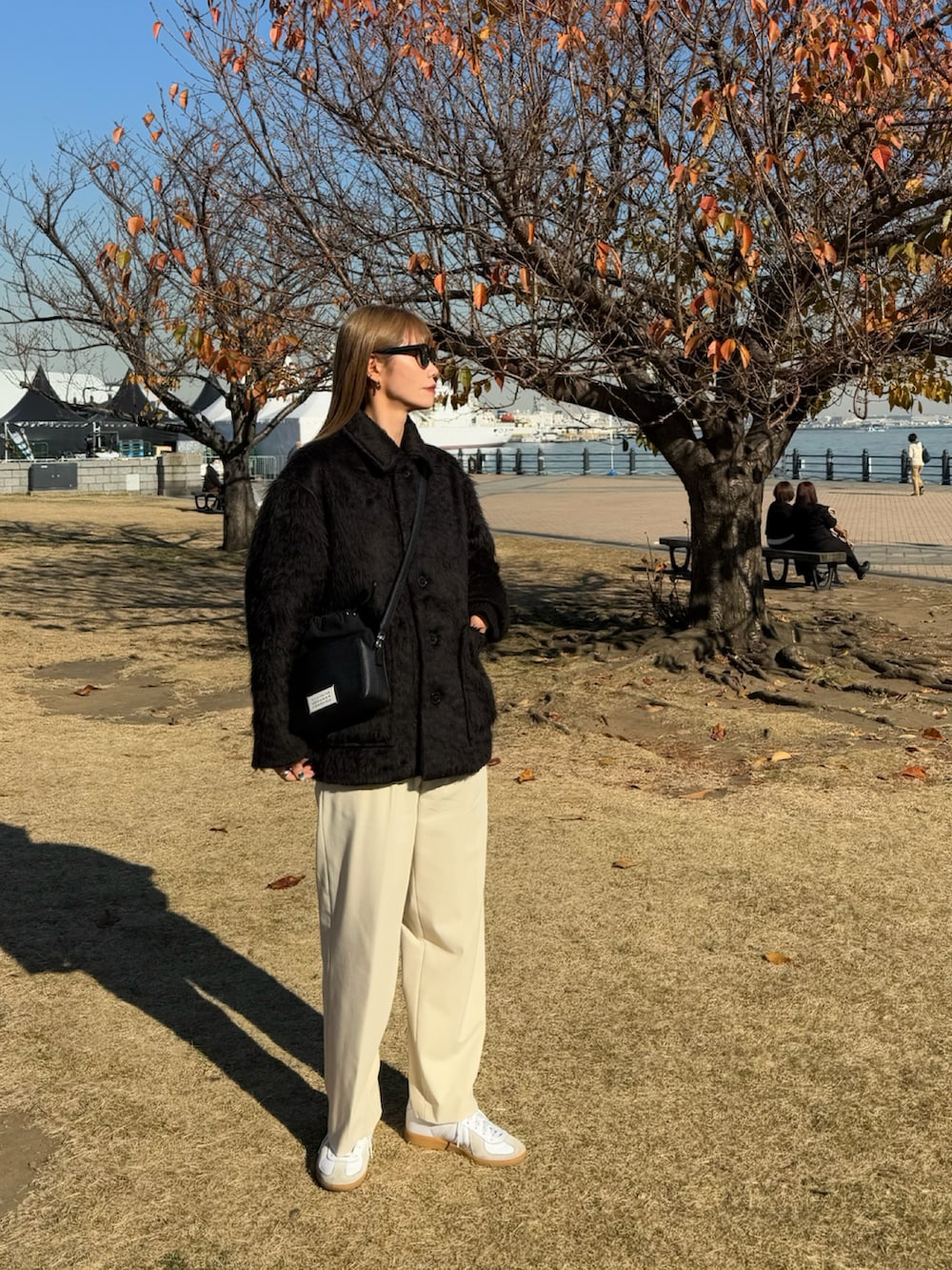 ブラック系のショルダーバッグ、ブラック系のその他アウターを着用したレディースの冬コーディネートの2枚目の写真