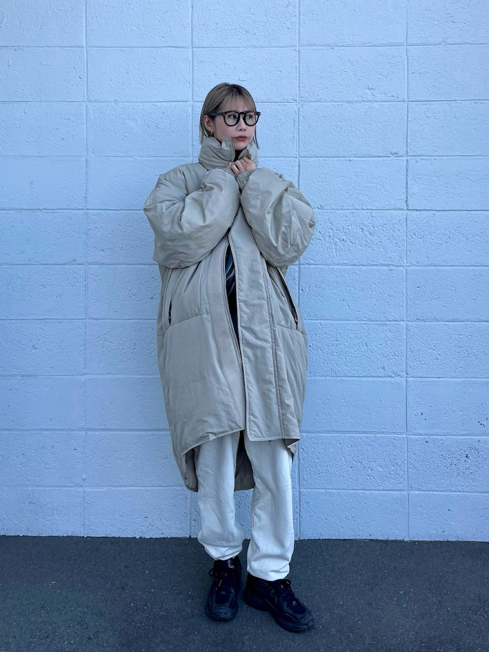 グリーン系のダウンジャケット/コート、グレー系のスウェット、ホワイト系のスウェットパンツを着用したレディースの冬コーディネートの2枚目の写真