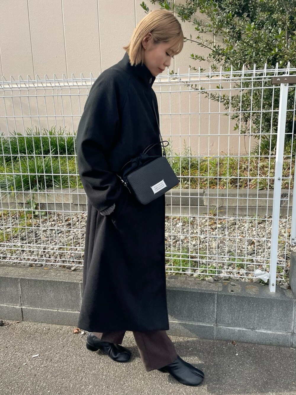 ブラック系のその他アウター、ブラック系のショルダーバッグ、ブラウン系のその他パンツを着用したレディースの冬コーディネートの2枚目の写真