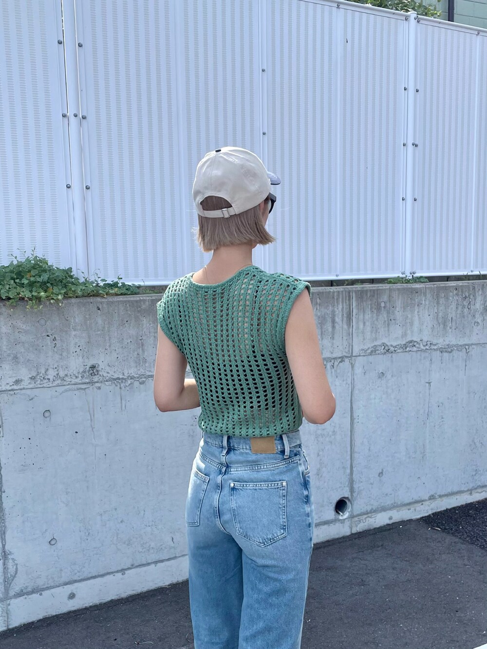 ブラック系のサンダル、ブルー系のパンツ、ブラック系のショルダーバッグを着用したレディースの夏コーディネートの3枚目の写真