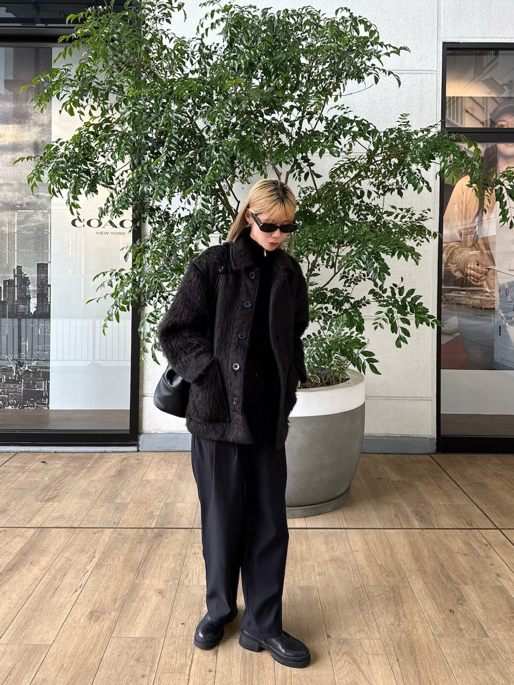 ブラック系のその他アウター、ブラック系のその他パンツ、ブラック系のニット/セーターを着用したレディースの春コーディネートの2枚目の写真