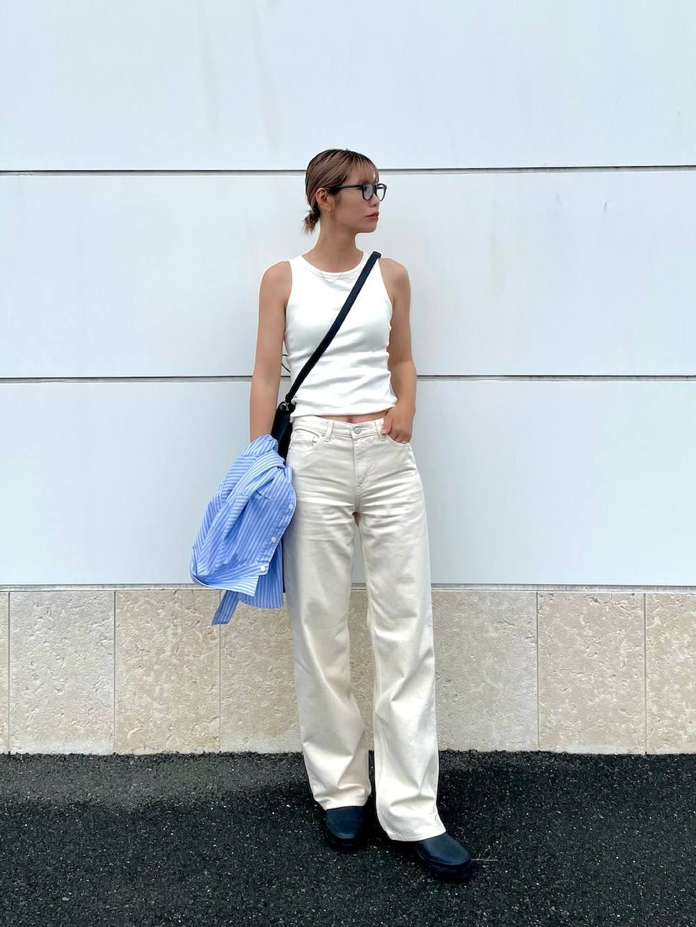 ブラック系のショルダーバッグ、ブラック系のブーツ、ホワイト系のパンツを着用したレディースの夏コーディネートの2枚目の写真