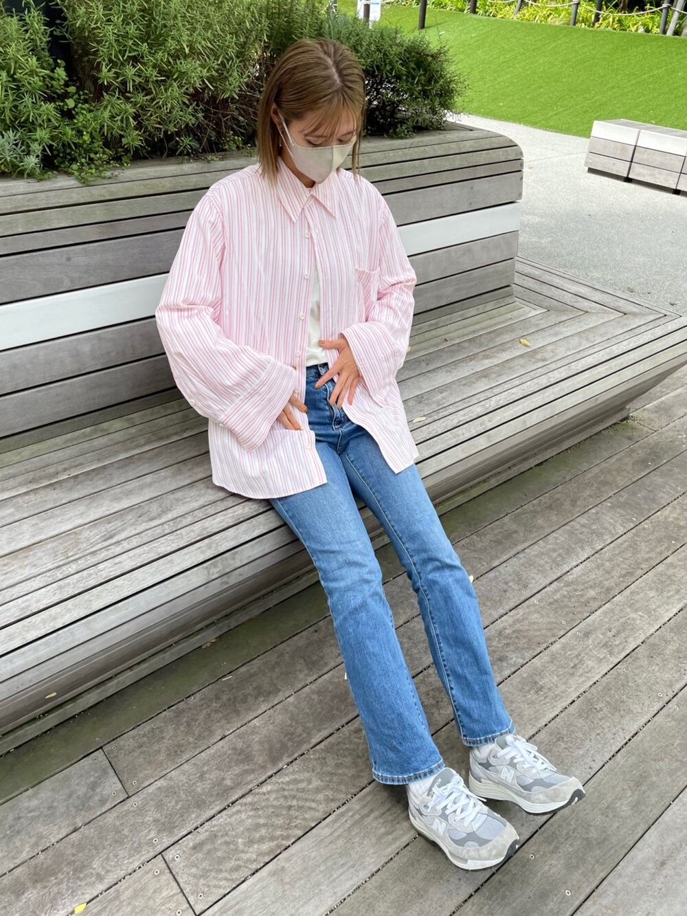 ピンク系のシャツ/ブラウス、ブルー系のパンツ、グレー系のスニーカーを着用したレディースの秋コーディネートの3枚目の写真