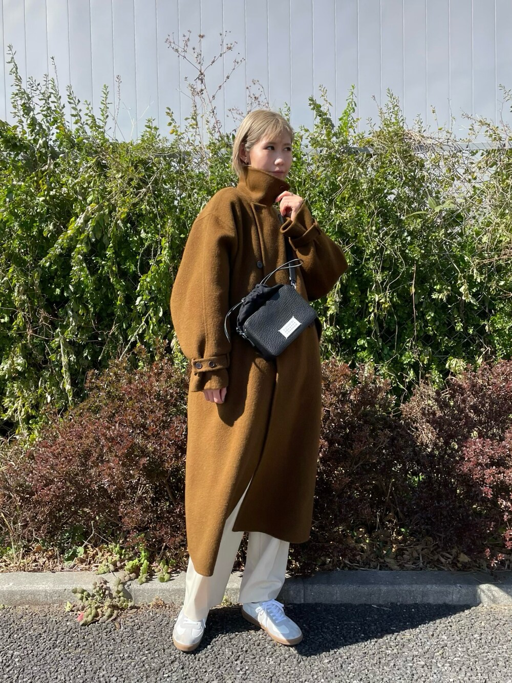 ホワイト系のシューズ、ブラウン系のジャケット/アウター、ブラック系のショルダーバッグを着用したレディースの冬コーディネートの3枚目の写真