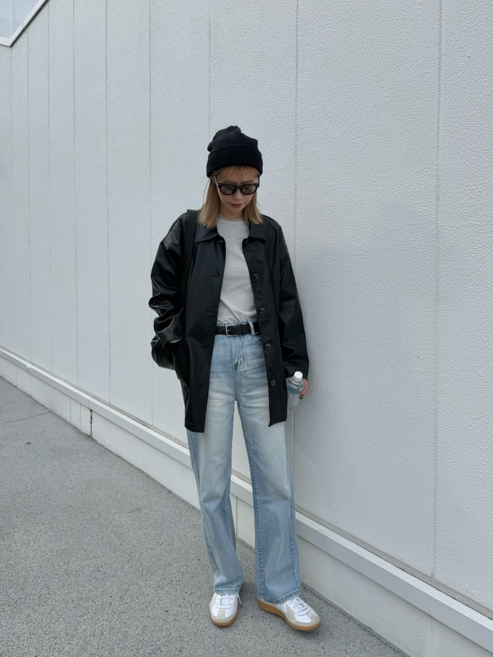 ブルー系のデニムパンツ、ホワイト系のスニーカー、ベージュ系のTシャツ/カットソーを着用したレディースの秋コーディネートの2枚目の写真