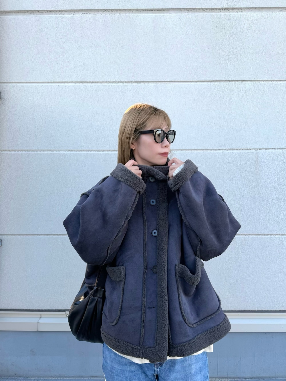 グレー系のムートンコート、ホワイト系のスニーカーを着用したレディースの冬コーディネートの3枚目の写真