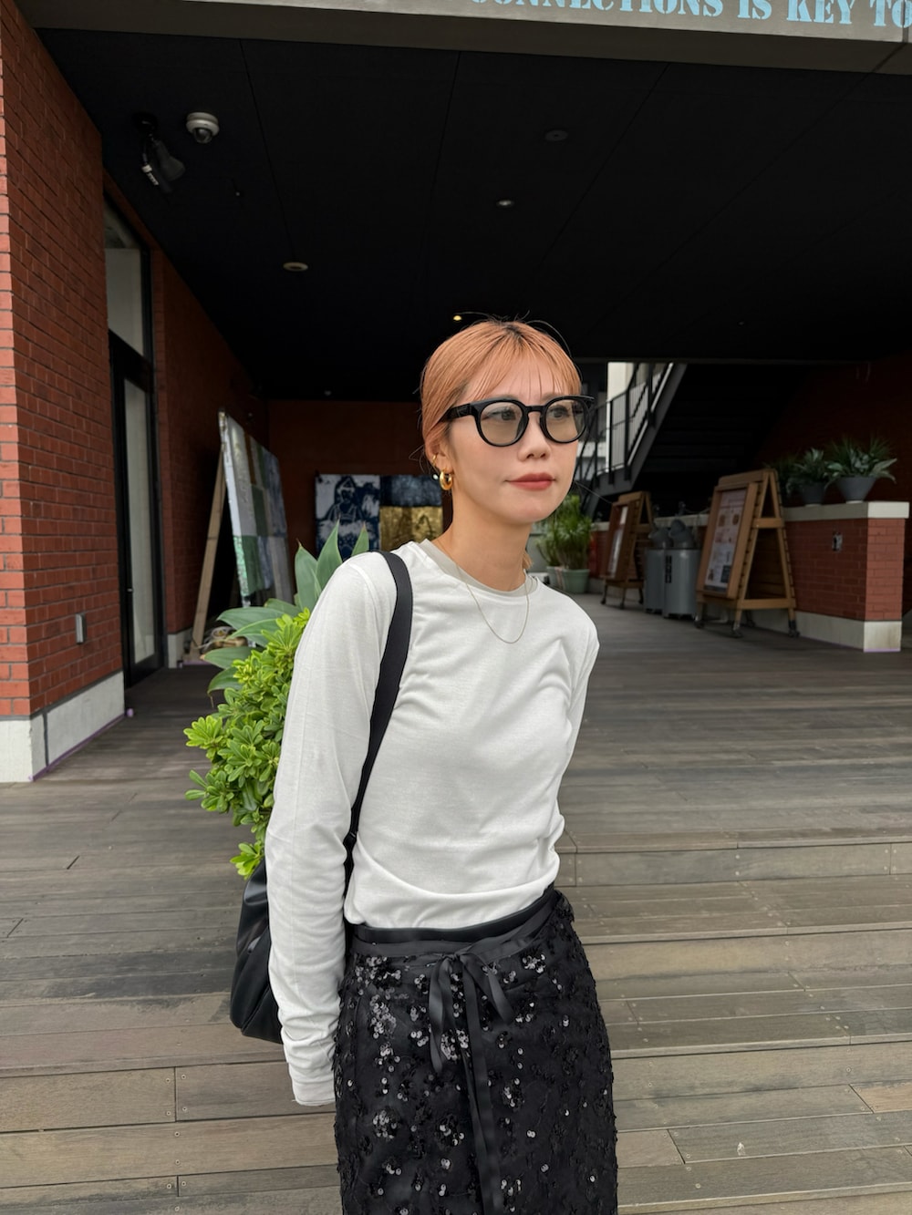 ベージュ系のTシャツ/カットソー、ブラック系のスカートを着用したレディースの秋コーディネートの3枚目の写真