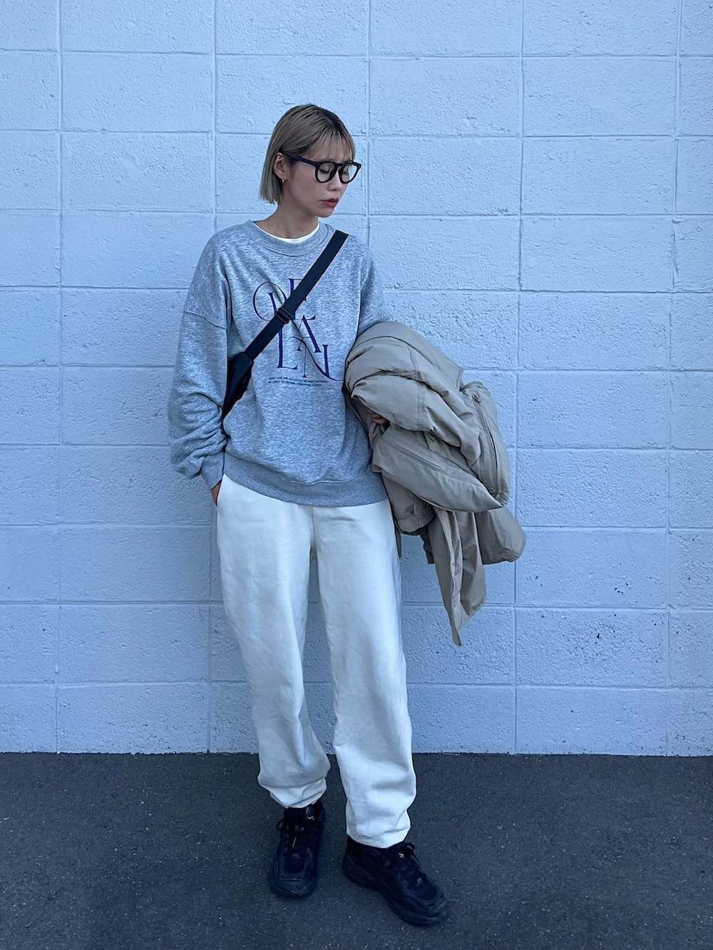 グリーン系のダウンジャケット/コート、グレー系のスウェット、ホワイト系のスウェットパンツを着用したレディースの冬コーディネートの3枚目の写真