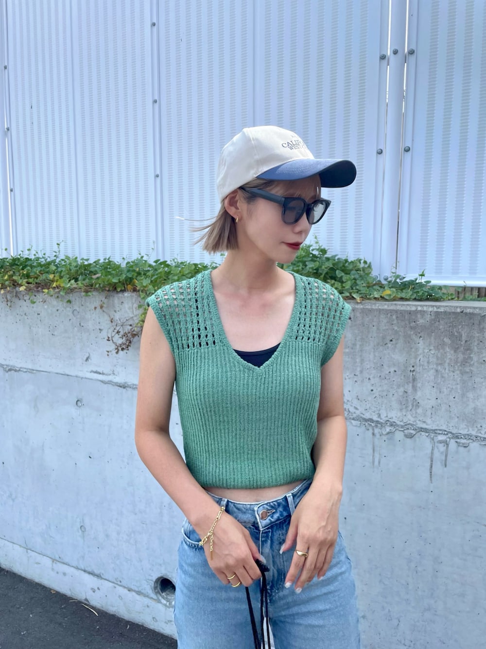 ブラック系のサンダル、ブルー系のパンツ、ブラック系のショルダーバッグを着用したレディースの夏コーディネートの4枚目の写真