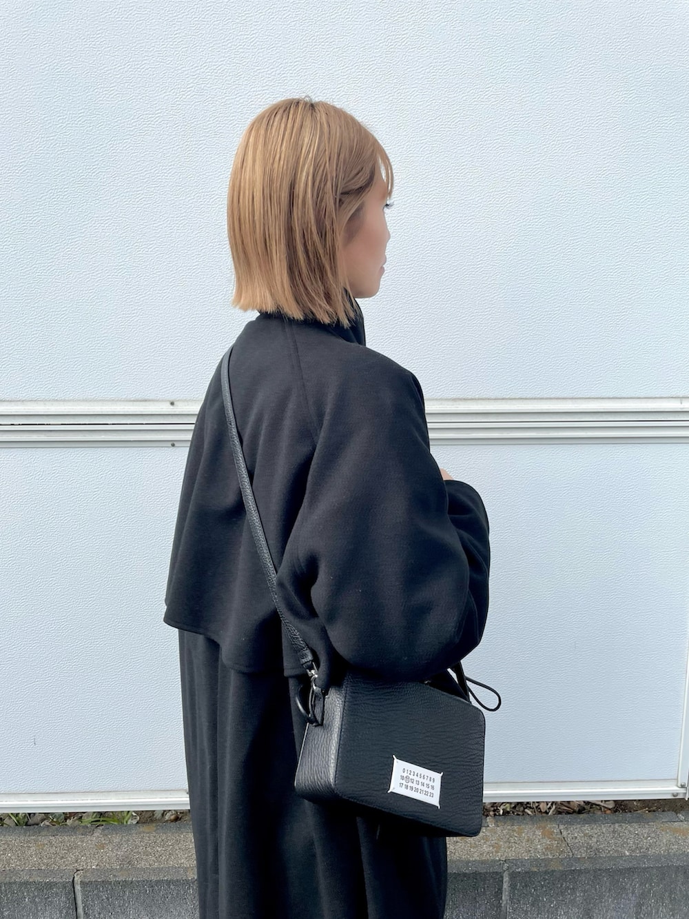 ブラック系のその他アウター、ブラック系のショルダーバッグ、ブラウン系のその他パンツを着用したレディースの冬コーディネートの3枚目の写真