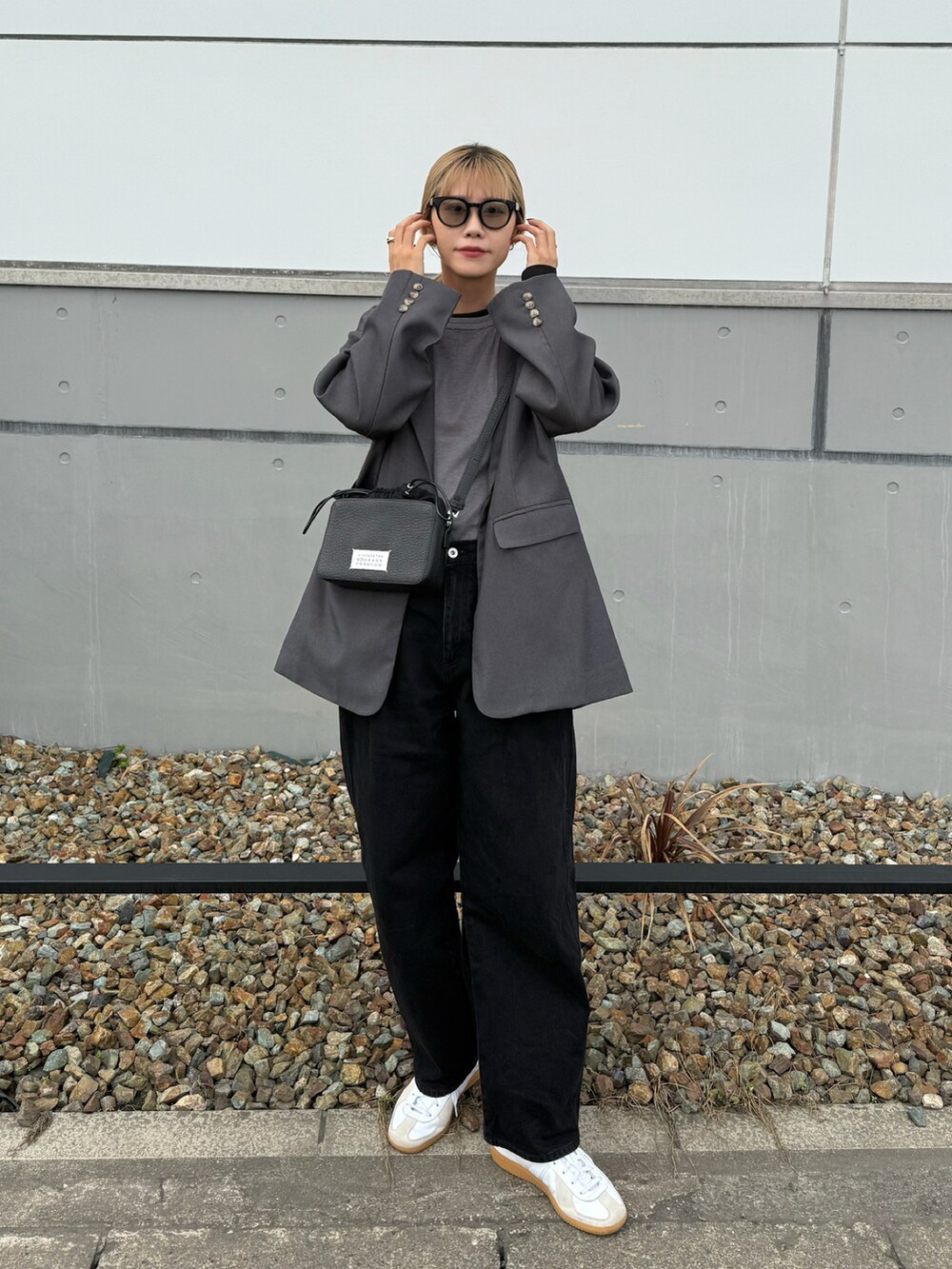 ブラック系のTシャツ/カットソー、グレー系のテーラードジャケット、ホワイト系のスニーカーを着用したレディースの秋コーディネートの2枚目の写真