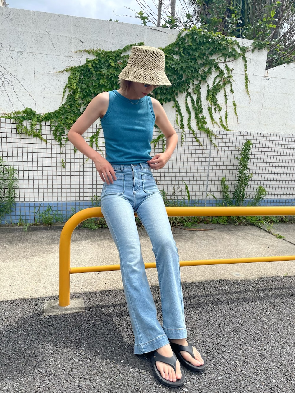 ブルー系のタンクトップ、ブルー系のデニムパンツ、ブラック系のサンダルを着用したレディースの夏コーディネートの2枚目の写真